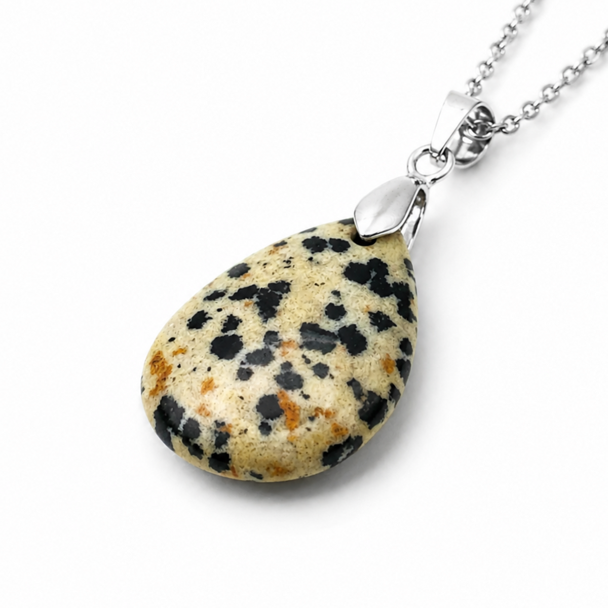 A teardrop-shaped Dalmatian Jasper pendant necklace made from a speckled stone with black, orange, and cream-colored spots, attached to a silver chain on a white background.