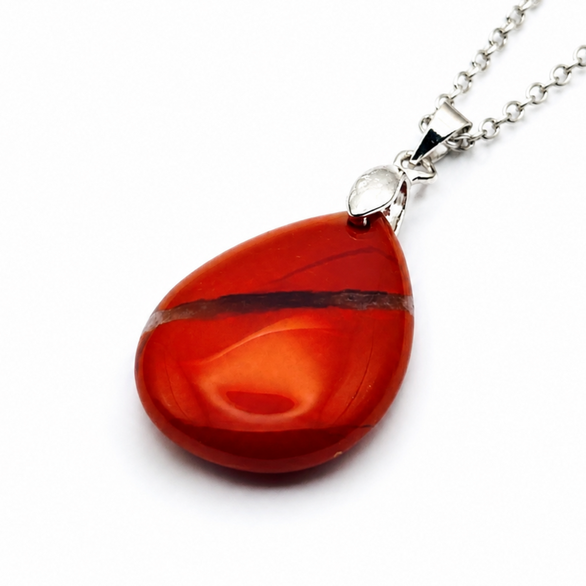 A teardrop-shaped red jasper pendant necklace with a polished silver-tone chain on a white background.